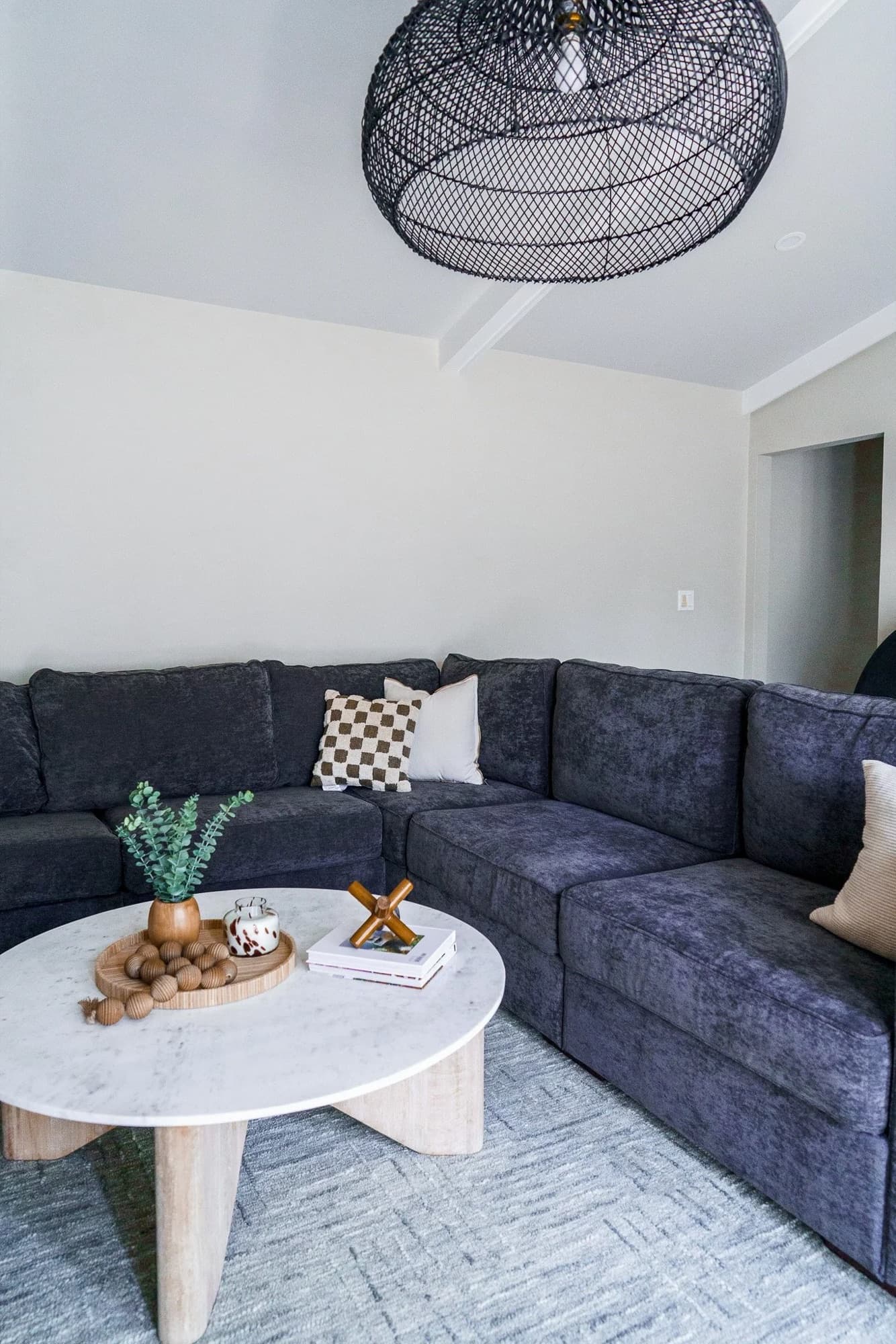 Furnished family room with a charcoal sectional and marble coffee table.